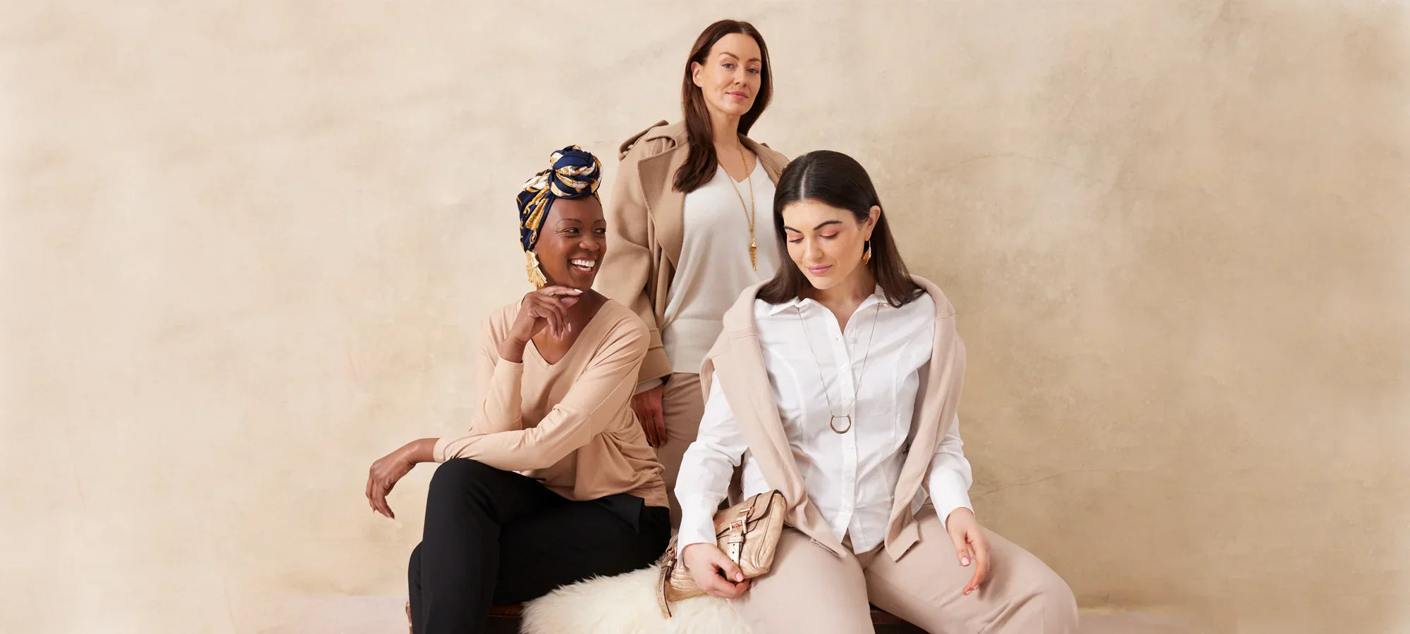 Three women in neutral tone clothing modelling for M