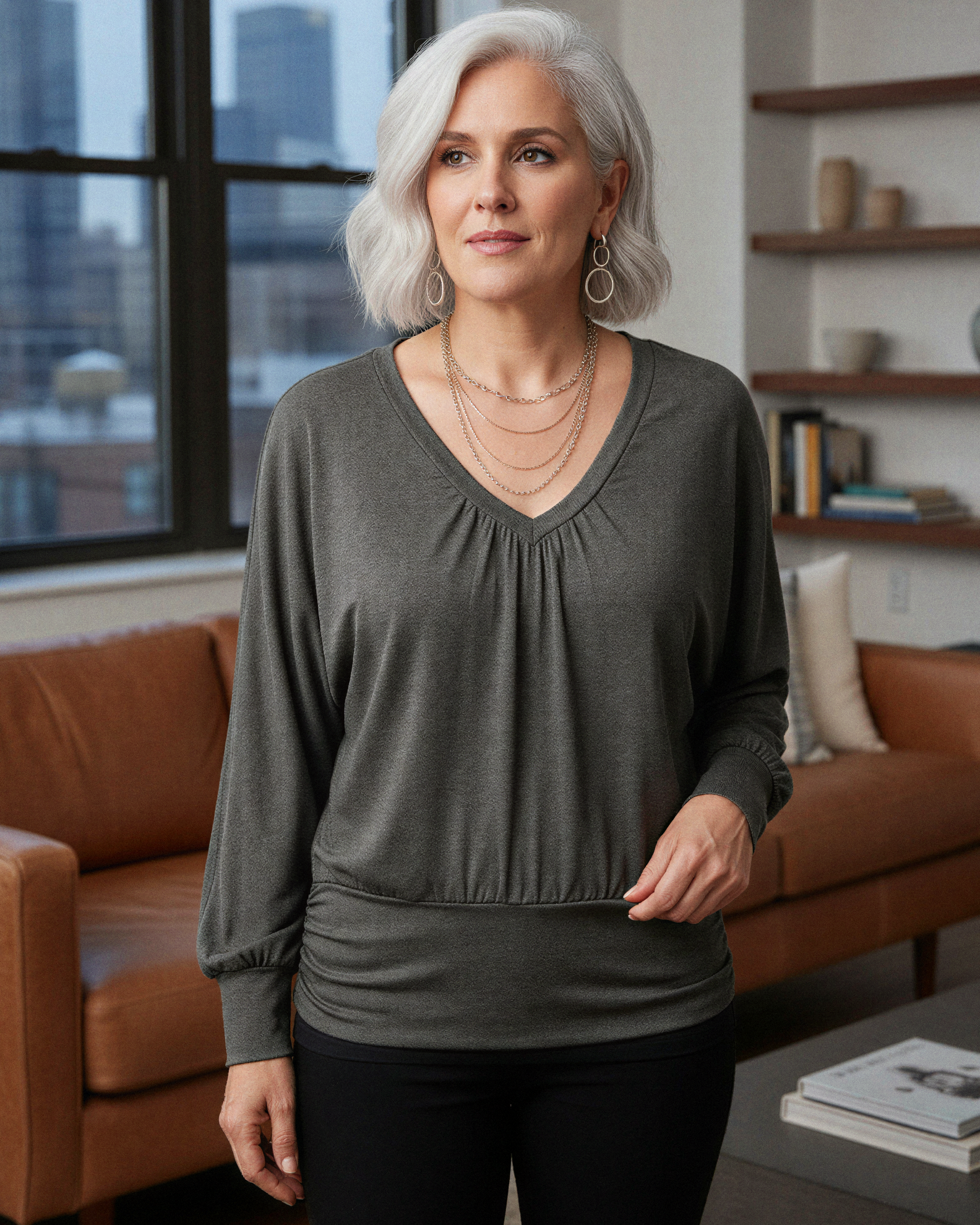 Woman wearing a green long-sleeve top in a living room setting