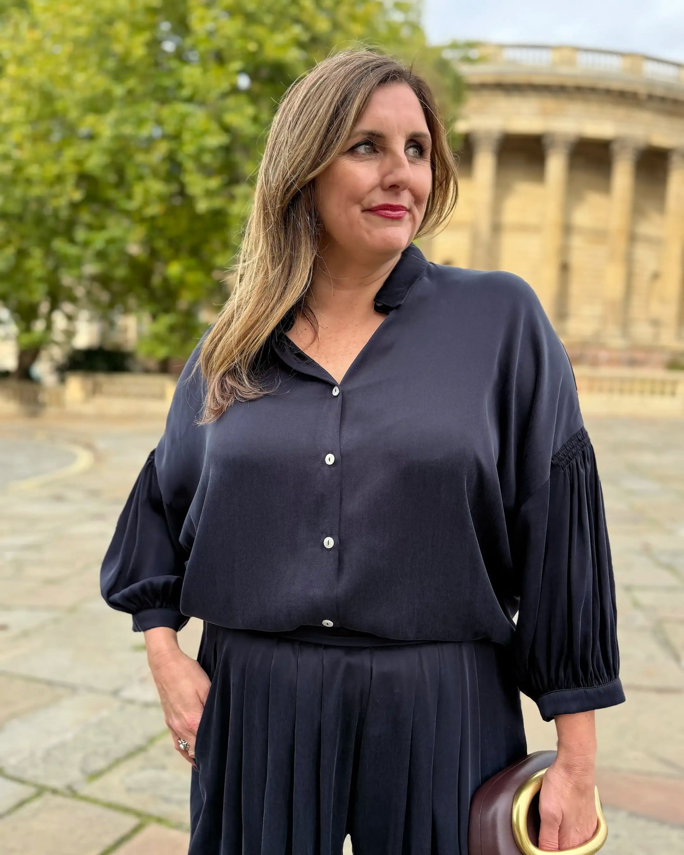Woman wearing navy silky shirt and matching wide-leg trouser for Melyr