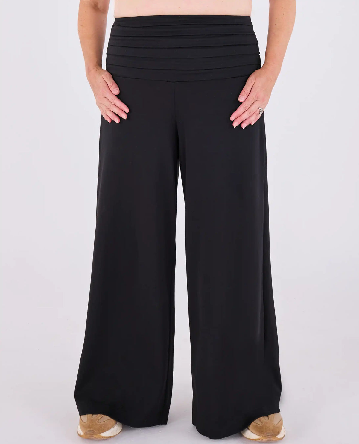 Black Ravello MELYRFLEX wide-leg trousers with a pleated high-waisted design, shown on a model from the waist down against a light gray background.